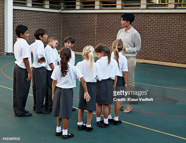 Schoolkids lining up in front of teacher