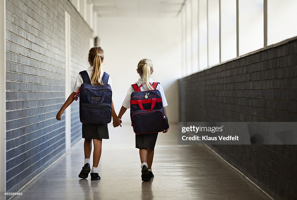 Schoolgirls walking hand in hand at school isle