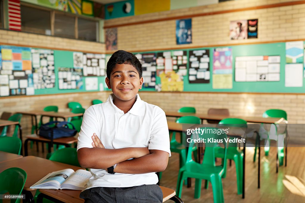 Confident schoolboy in classroom