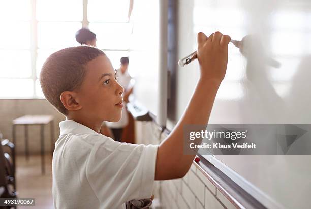schoolboy writing on whiteboard - kid with markers fotografías e imágenes de stock
