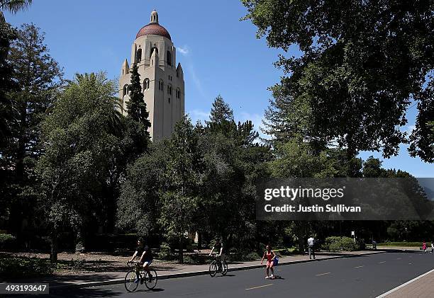 People ride bikes past Hoover Tower on the Stanford University campus on May 22, 2014 in Stanford, California. According to the Academic Ranking of...