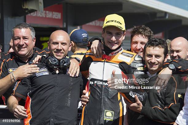 Lorenzo Baldassarri of Italy and Forward Racing celebrates the third place with team under the podium at the end of the Moto2 race during the MotoGP...
