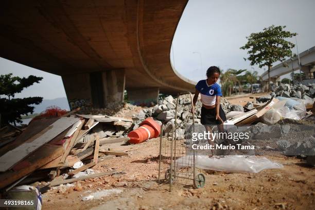 Viviane Sabino de Souza searches for recyclable metal near her makeshift dwelling beneath a stretch of the Transcarioca BRT highway being constructed...