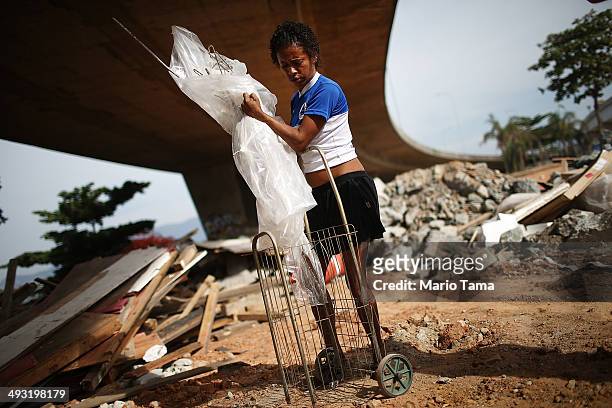 Viviane Sabino de Souza collects recyclable metal near her makeshift dwelling on a stretch of the Transcarioca BRT highway being constructed on May...