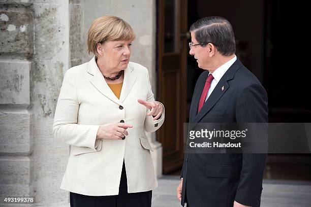 In this handout photo provided by the German Government Press Office , German Chancellor Angela Merkel and Turkish Prime Minister Ahmet Davutoglu...
