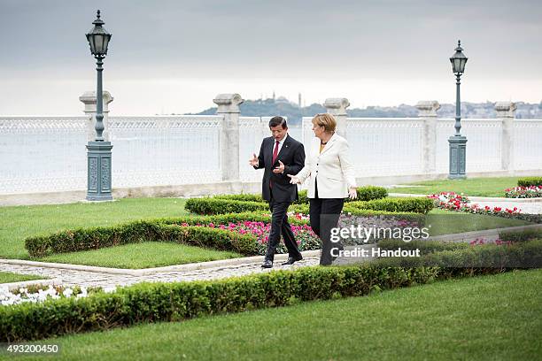 In this handout photo provided by the German Government Press Office , German Chancellor Angela Merkel and Turkish Prime Minister Ahmet Davutoglu...