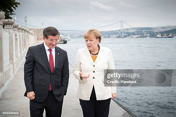 In this handout photo provided by the German Government Press Office , German Chancellor Angela Merkel and Turkish Prime Minister Ahmet Davutoglu...