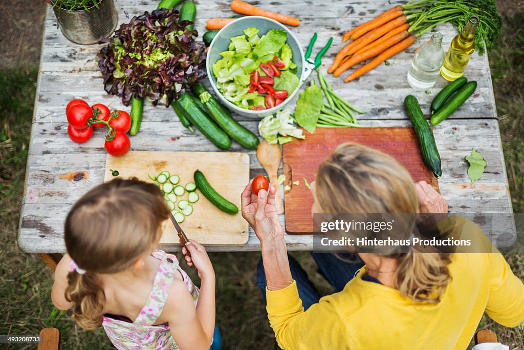 Mother And Daughter Preparing Salad