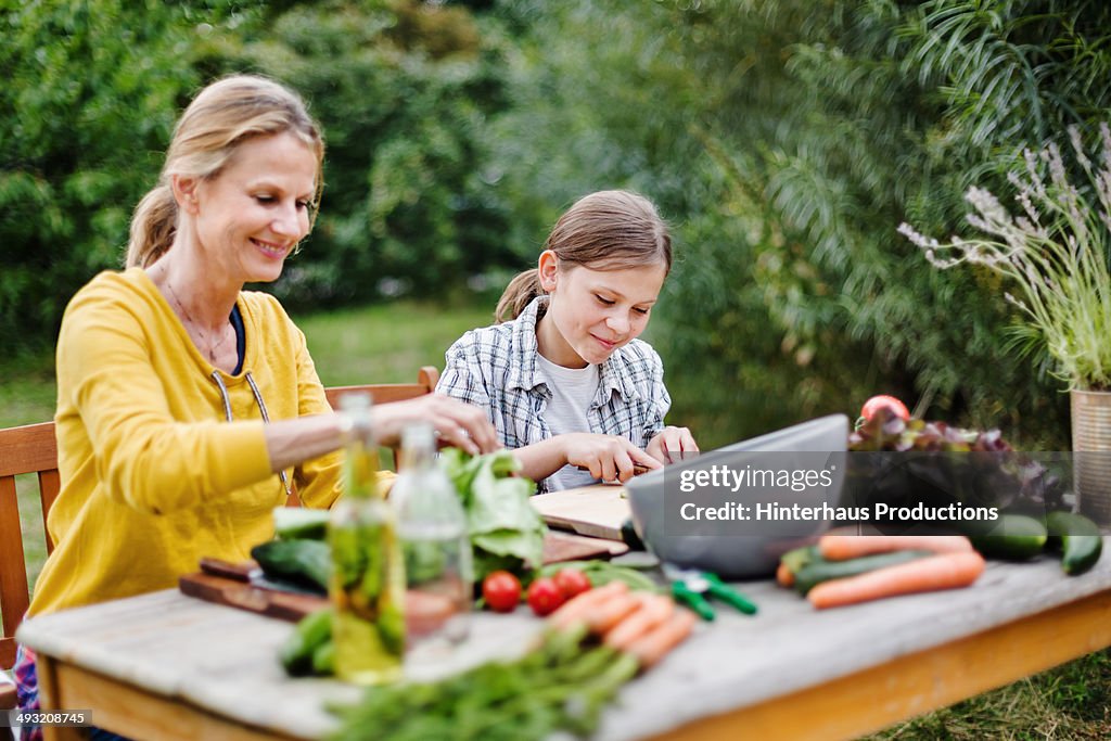 Mother And Daughter Preparing Salad