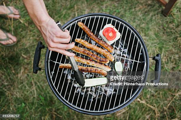 barbeque grill with sausages - overhead view stock-fotos und bilder