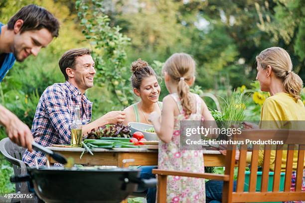 family at barbeque in a garden - barbecue photos et images de collection