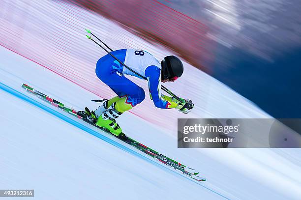 young male skier at straight downhill race - alpineskiën stockfoto's en -beelden