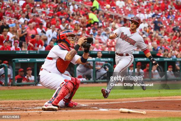 Martin Prado of the Arizona Diamondbacks beats the throw to Yadier Molina of the St. Louis Cardinals to score a run in the first inning at Busch...