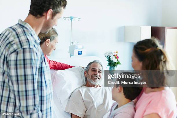 family visiting happy man in hospital ward - family hospital old stock pictures, royalty-free photos & images