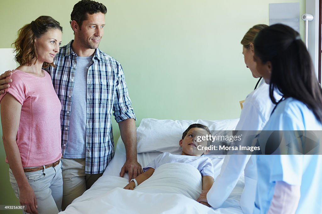 Parents looking at doctor attending their boy