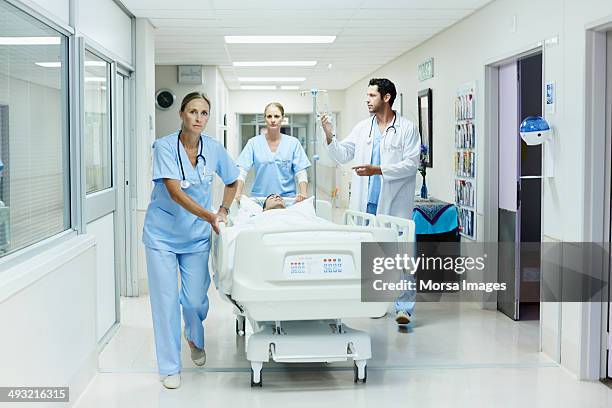 healthcare workers rushing patient in hospital - stretcher photos et images de collection