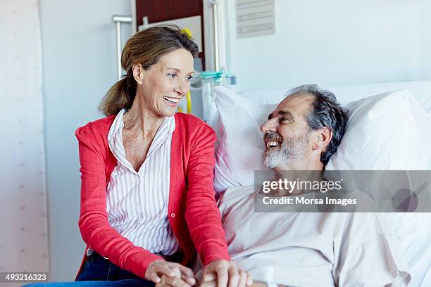 woman visiting man in hospital ward - hospital visit stock-fotos und bilder