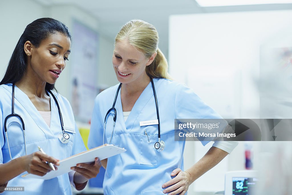 Nurses discussing over documents in hospital