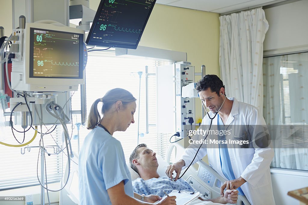 Doctor examining man with colleague