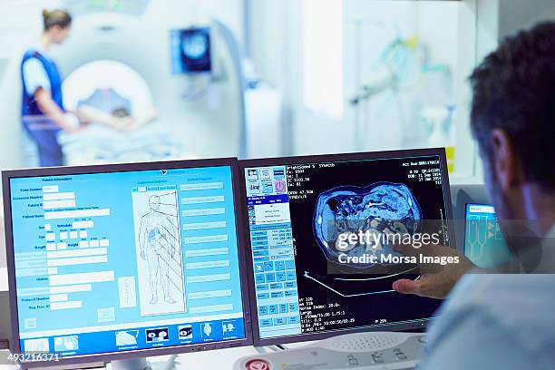 doctor running ct scan from control room - digital healthcare stock pictures, royalty-free photos & images