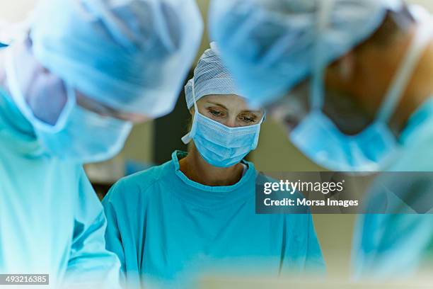 team of surgeons in operation room - operating room foto e immagini stock