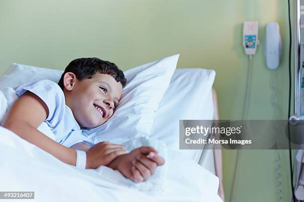 happy boy relaxing in hospital ward - child in hospital stock-fotos und bilder