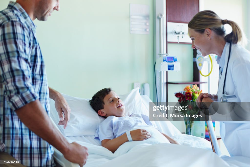 Doctor attending ill boy with father in hospital