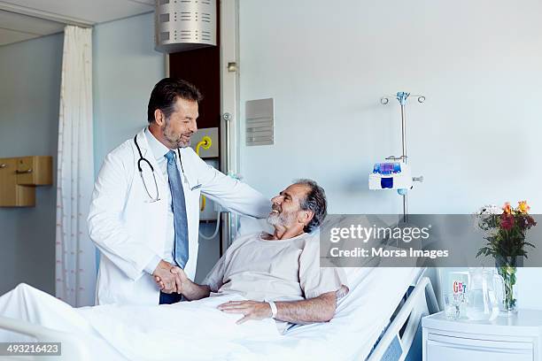 doctor greeting patient in hospital ward - flower bed stockfoto's en -beelden