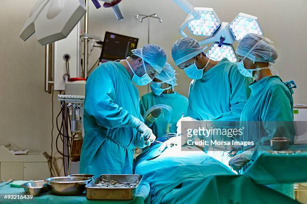 group of surgeons in operating room - surgery photos et images de collection