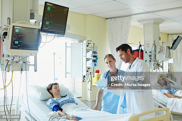 doctors examining reports of patient in icu - critical care stock pictures, royalty-free photos & images