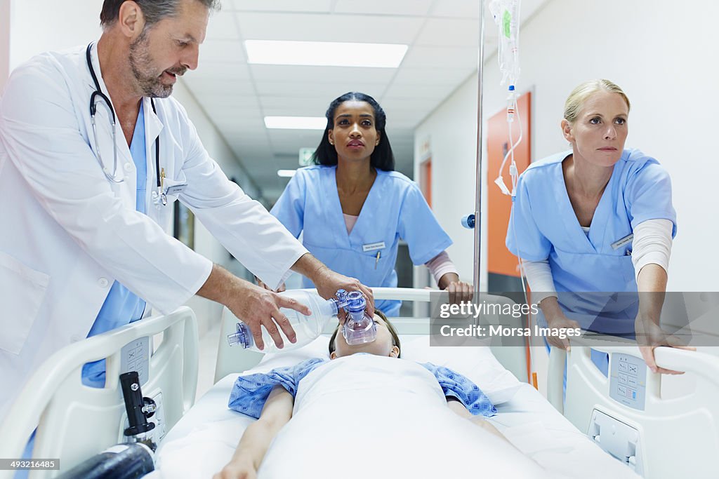 Doctor and nurses rushing patient in corridor