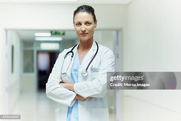 confident doctor standing arms crossed - female doctor stockfoto's en -beelden