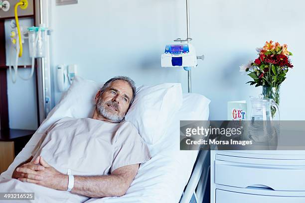 thoughtful man relaxing in hospital ward - man in hospital stockfoto's en -beelden