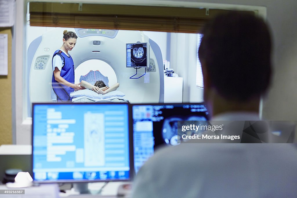 Doctor preparing patient for CT scan