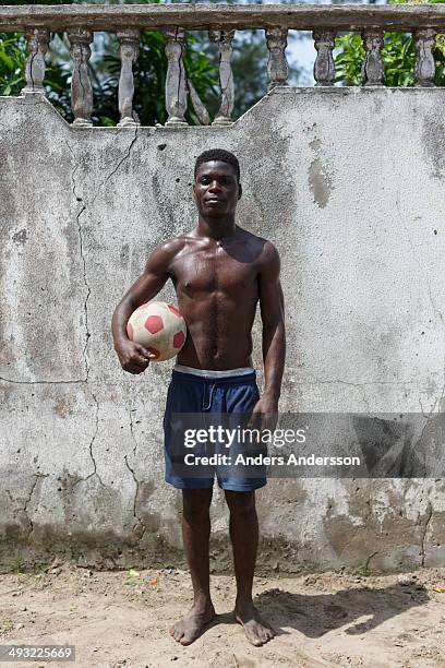 A young  nigerian man  holding a soccerball