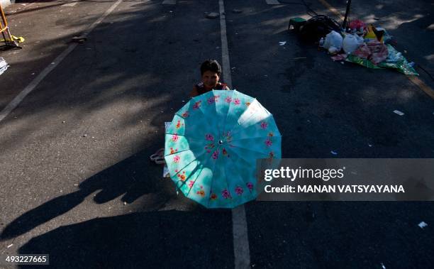 Lone Thai anti-government protester sits on the road at their main camp-site outside Government House in Bangkok on May 23, 2014 a day after Thai...