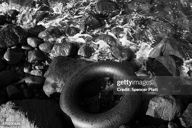 An inflated inner tube lays next to other items discarded by migrants arriving by boat from Turkey along a Lesbos beach where thousands of objects...