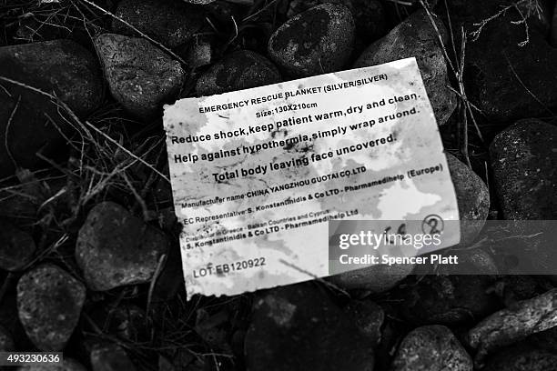 Paper giving directions for an emergency thermal blanket lays next to other items discarded by migrants arriving by boat from Turkey along a Lesbos...