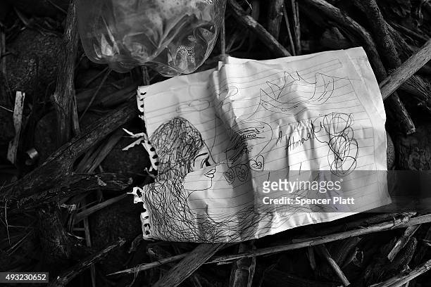 Childs drawing is viewed next to other discarded items by migrants arriving by boat from Turkey along a Lesbos beach where thousands of objects can...