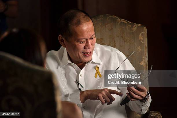 Benigno Aquino, the Philippines' president, checks his mobile phone during a Bloomberg Television interview at the Malacanang Palace compound in...