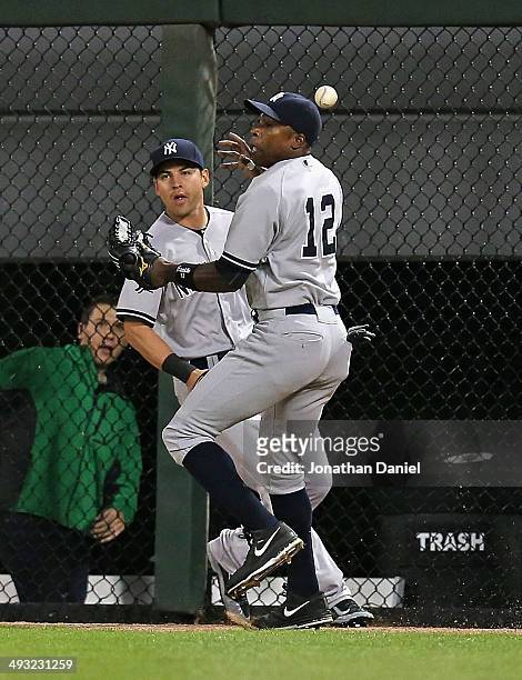 Alfonso Soriano of the New York Yankees misplays a ball hit off the wall by Gordon Beckham of the Chicago White Sox next to teammate Jacoby Ellsbury...