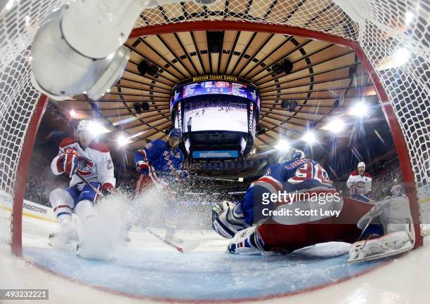 Alex Galchenyuk of the Montreal Canadiens deflects a shot on goal past Henrik Lundqvist of the New York Rangers in the overtime period of Game Three...