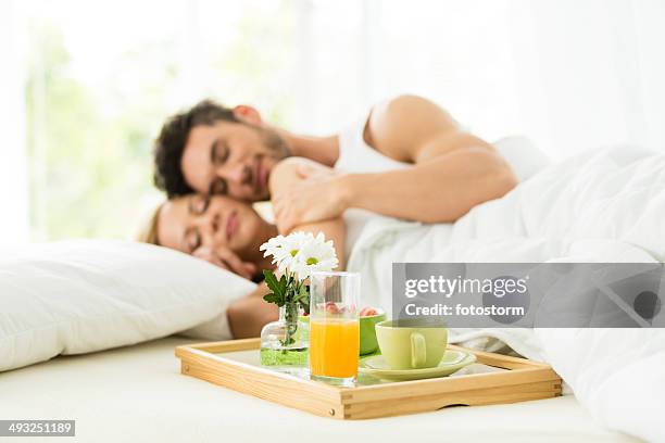 couple having breakfast in bed - romantic young couple sleeping in bed stock pictures, royalty-free photos & images