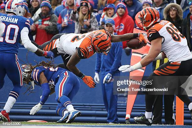 Jeremy Hill of the Cincinnati Bengals leaps over Stephon Gilmore of the Buffalo Bills for a touchdown during the first half at Ralph Wilson Stadium...