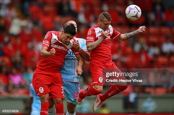 Jordan Silva and Dario Bottinelli of Toluca struggles for the ball with Emanuel Villa of Queretaro during the 13th round match between Toluca and...
