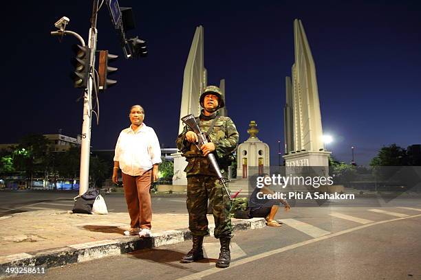 Thai soldier stands guard at Democracy monument after a curfew started at 10pm on May 22, 2014 in Bangkok. Thai soldiers began clearing the sites of...