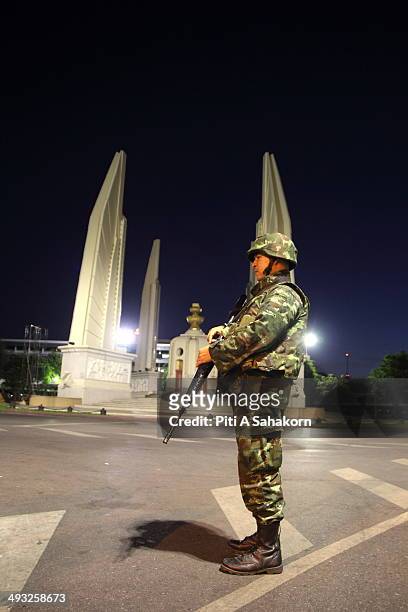 Thai soldier stands guard at Democracy monument after a curfew started at 10pm on May 22, 2014 in Bangkok. Thai soldiers began clearing the sites of...