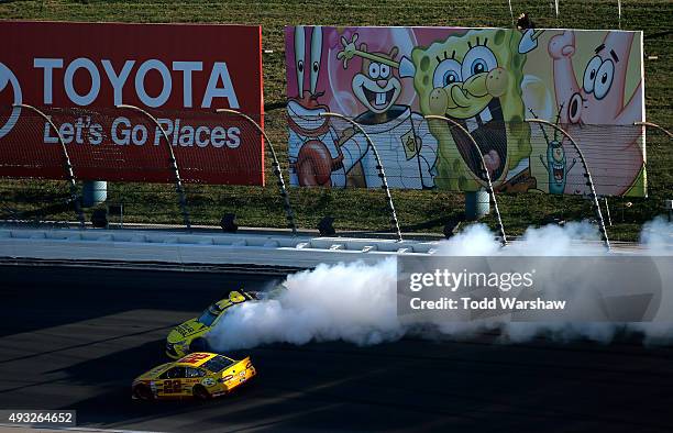 Matt Kenseth, driver of the Dollar General Toyota, spins as Joey Logano, driver of the Shell Pennzoil Ford, races by during the NASCAR Sprint Cup...