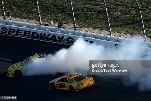 Matt Kenseth, driver of the Dollar General Toyota, spins as Joey Logano, driver of the Shell Pennzoil Ford, races by during the NASCAR Sprint Cup...