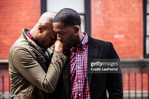 mismo sexo pareja posando en las calles de la ciudad de nueva york - hombre gay fotografías e imágenes de stock